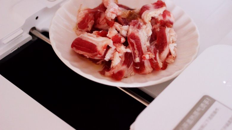 百吃不厌的双椒炒肉,炒菜机提示音响起后,加入腌制好的五花肉条开始翻炒,用炒菜锅的做法是把腌制好的五花肉条大火爆炒至颜色变白。