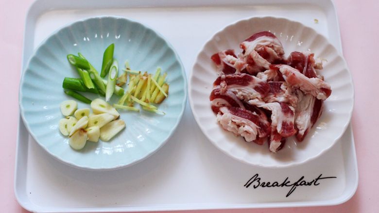 百吃不厌的双椒炒肉,用刀把蒜切成薄片,葱和姜切丝,<a style='color:red;display:inline-block;' href='/shicai/ 428'>五花肉</a>切成条状备用。