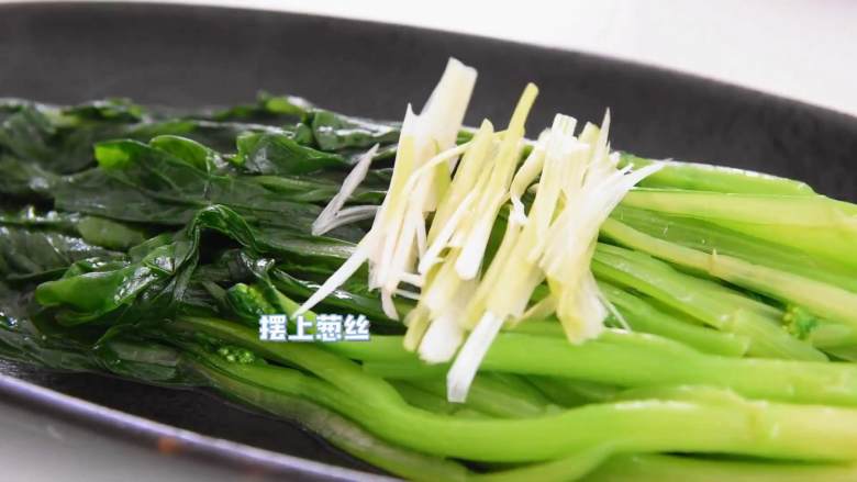 白灼菜心,清新爽口不油腻,记得多吃蔬菜哦,菜心炒熟装盘,摆上葱丝。