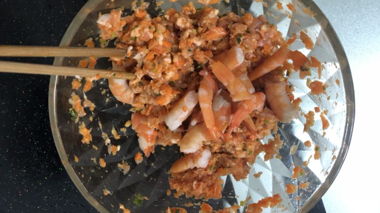 水晶虾饺,用筷子按一个方向搅拌馅料,多搅拌一会,搅拌均匀后加入虾段。