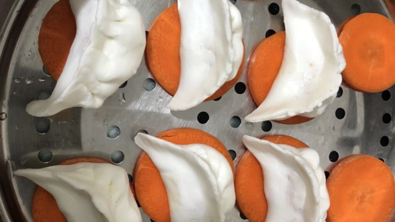 水晶虾饺,像包饺子那样包好,摆在胡萝卜段上。(摆胡萝卜上可以防止粘粘。)