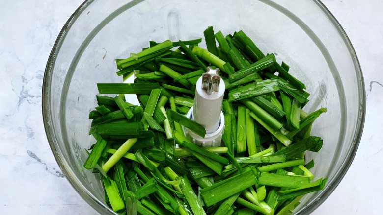 美味韭菜饼,接着把切好的韭菜放入搅拌机里,加入适量清水,搅打成韭菜汁。