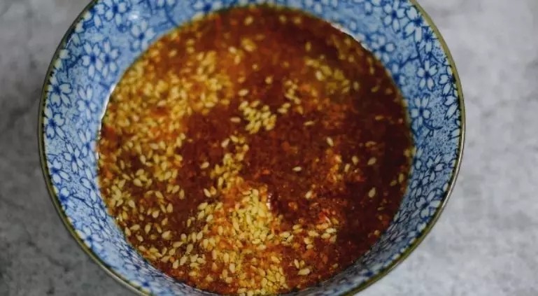 口水鸡这样吃才叫爽,入口即化,一只完全不够吃,碗中倒入辣椒粉、白芝麻,再倒入热油