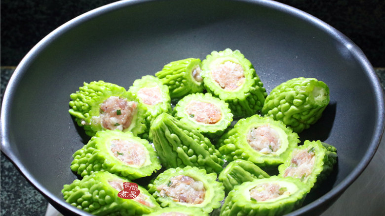 客家酿三宝,烧热炒锅,倒入食用油,将苦瓜两面煎一下,盛起,接着煎茄子