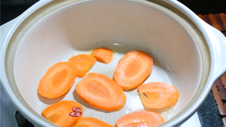 客家酿三宝,砂锅内倒入少许食用油,在锅底内铺上<a style='color:red;display:inline-block;' href='/shicai/ 25'>胡萝卜</a>片,也可以用白萝卜或大头菜、大白菜梗垫底,防止粘锅外,还能增加食物的风味