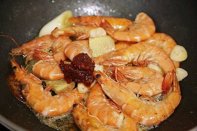 鲜虾粉丝煲,将葱段,姜片,蒜片放入锅中煸炒出香味。再往锅中放入一勺郫县豆瓣儿酱,煸炒出红油。