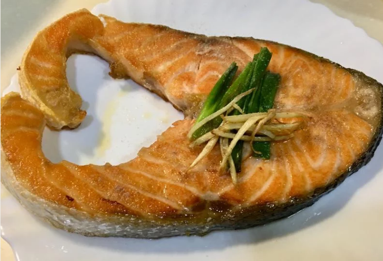 煎鮭鱼,直至鮭鱼双面呈现金黄即可取出,将姜丝葱段至於鮭鱼上方。
