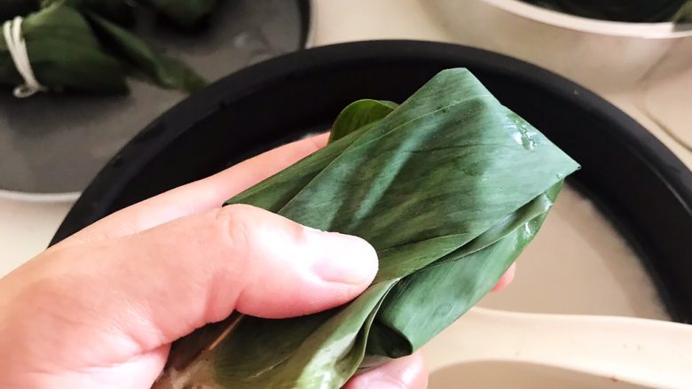 蜜豆糯米粽子,再把上面折过来,一个粽子就包好了