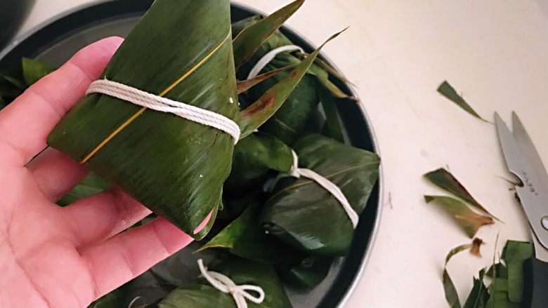 蜜豆糯米粽子,把包好的粽子边缘用剪刀剪断,这样粽子就非常整齐了