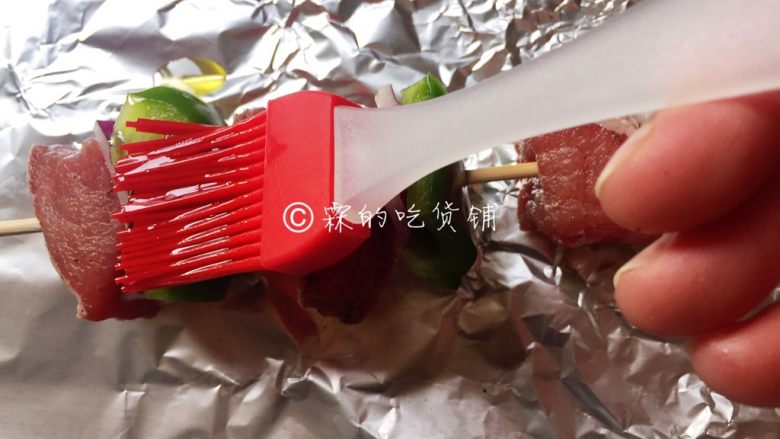 烤牛肉串,用刷子把牛肉串的前后左右都刷上一遍。