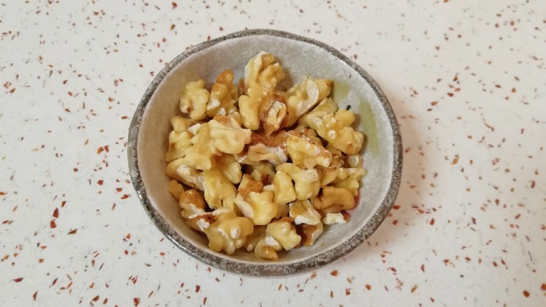 枣泥核桃卷,核桃仁烤熟以后趁热揉搓一下去皮(不用完全去掉),用刀切碎。