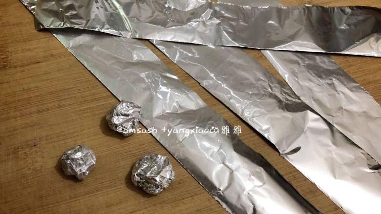 砂锅烤地瓜,把锡纸剪成宽度一样的长条,然后搓成大小一致的小圆球。