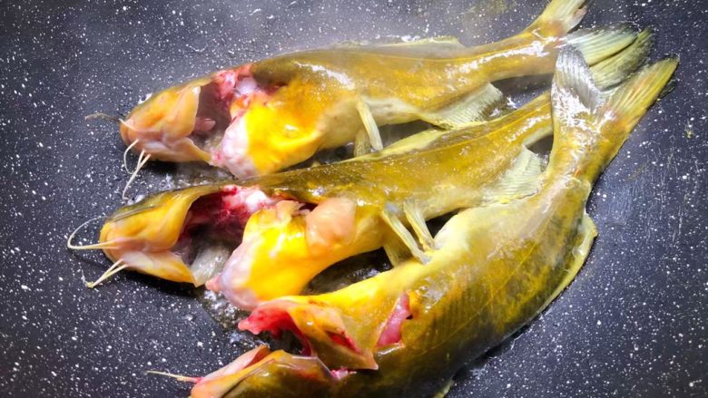 黄骨鱼豆腐汤,热锅放入适量油,烧至8成热,把洗干净的黄骨鱼放入煎,煎好一面翻另一面继续煎制。