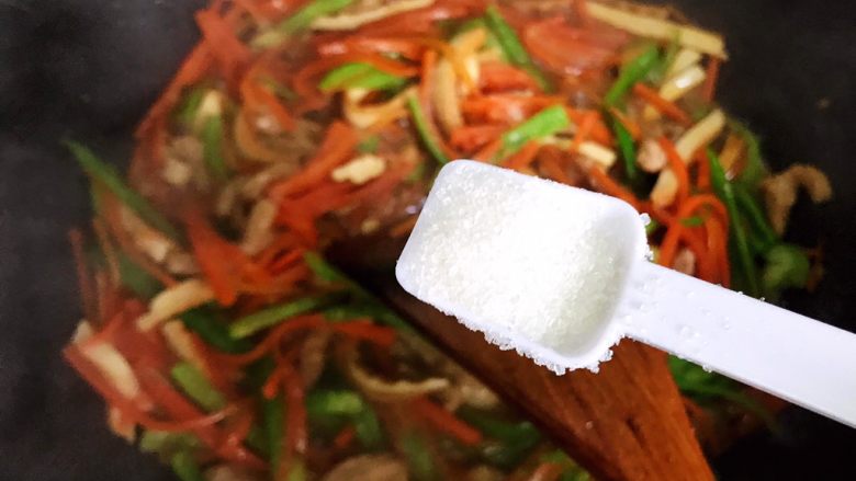 蚝油胡萝卜青椒香干炒肉丝,加一小勺细砂糖,翻炒均匀,即可