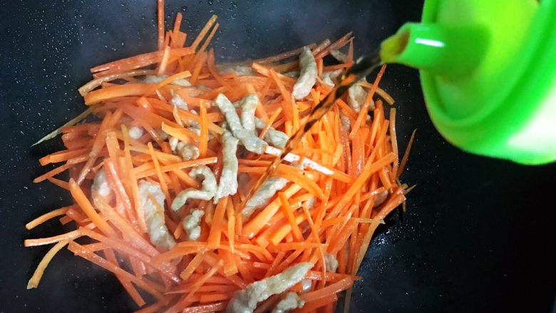 蚝油胡萝卜青椒香干炒肉丝,烹适量料酒,翻炒均匀