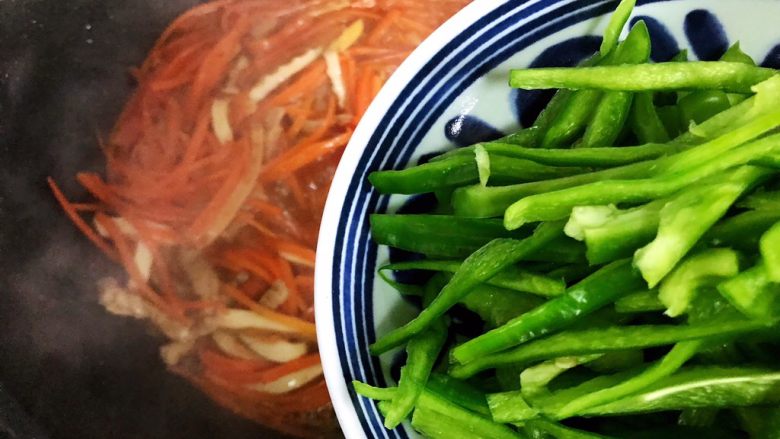 蚝油胡萝卜青椒香干炒肉丝,加入青椒,翻炒30秒