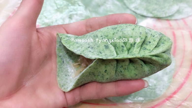 菠菜柳叶包子,取一张包子皮码上适量的馅料,用拇指和食指捏一个褶儿,然后顺着食指方向捏褶,捏完稍整形整成弯弯的柳叶形状