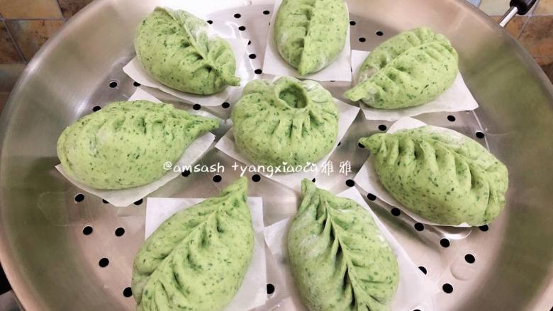 菠菜柳叶包子,蒸锅此时可以加入水开小火微微加热,让整个锅体以及内部温热湿润,同时把包好的包子底部垫油纸放在蒸上,放的时候要留出空间来,以免发酵的时候包子都挤在一起了,蒸锅关火,盖上锅盖发酵15分钟,发酵好的休积明显变大