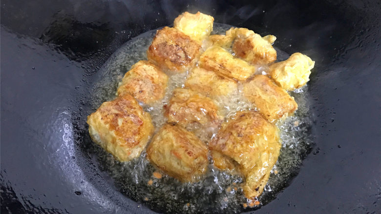 豆腐衣肉卷,锅中倒入适量油,把豆腐衣肉卷放入锅中,炸至表皮呈金黄色后捞出。