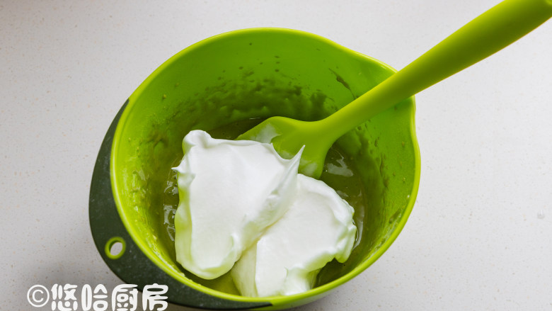 抹茶草莓蛋糕卷,取1/3的蛋白霜至蛋黄糊中,用刮刀以切拌的方式拌匀。
