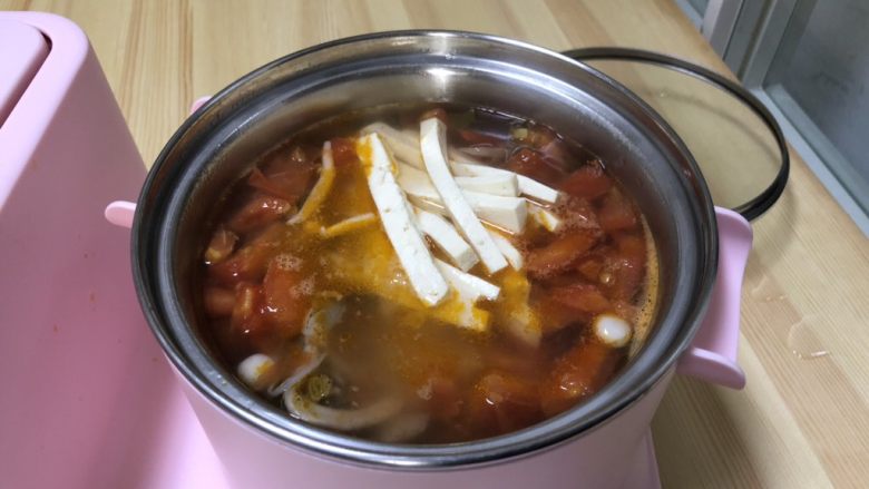 番茄豆腐菌菇汤,炒好后的番茄倒入锅中,菌菇也倒入煮锅中加入一大碗水。