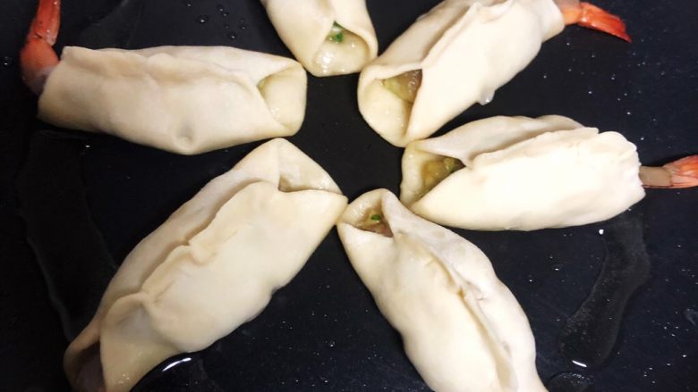 黄金虾饺,煎至底部金黄,加入少许水盖上锅盖焖煮(水少量即可,不能没过饺子)