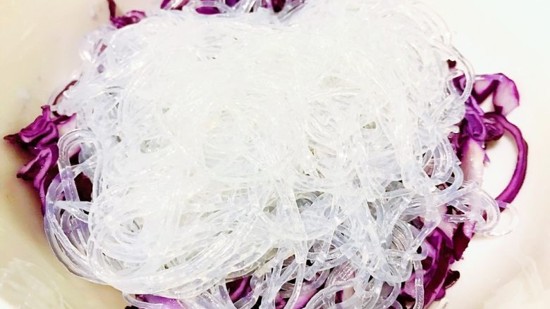 紫甘蓝拌粉丝,沥干,放入紫甘蓝碗中。