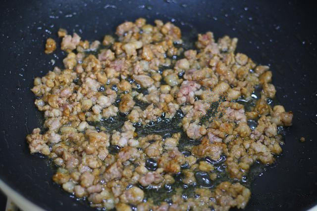 青豆肉末蒸豆腐,热锅温油,把腌制好的肉末下锅,迅速搅拌开,炒至变色;