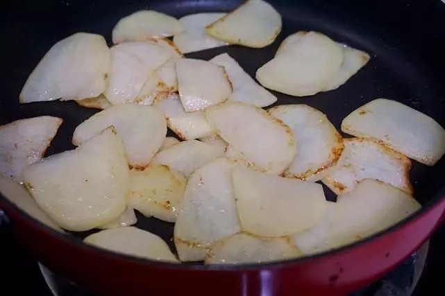 干锅鸡翅,接下来利用刚才剩余的鸡翅的油脂,继续用来煎土豆片,土豆比较吃油,又容易粘锅,所以要勤翻动,觉得太粘了,可以加入适量食用油。