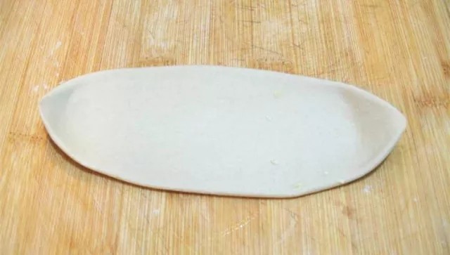 河南烩面,将揉搓好的长条,用擀面杖擀成面片备用。