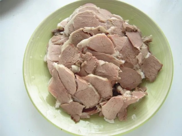 河南烩面,煮到汤汁浓白。加入羊油再煮10分钟左右,捞出羊肉,晾凉后,切片备用。