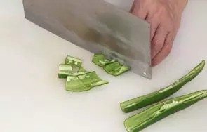 回锅羊肉片, 将洗净的青椒对半切开，剔去籽，切成小块。