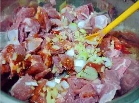 粉蒸羊肉,把羊肉捞出,控干水后,加入姜末、一半的葱末、豆瓣酱、酱油。