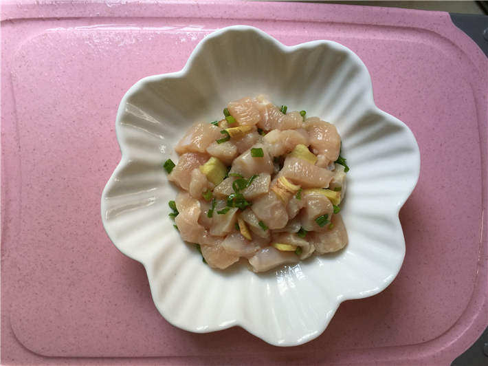 玉米鸡肉肠,鸡胸肉切小块,香葱切末,鸡胸肉中放入葱末和姜片,搅拌均匀腌制 10 分钟,去除鸡肉的腥味。