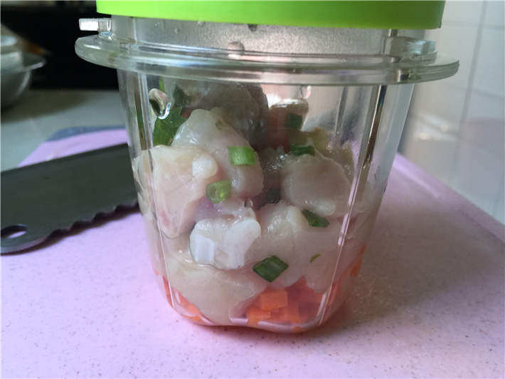 玉米鸡肉肠,腌制好鸡肉之后把姜片取出,将鸡肉块和葱花放入料理机,加入胡萝卜丁,搅打成细腻的泥状。PS:肉泥一定非常细腻才可以哦,否则做出来会有颗粒感,成型度不佳。