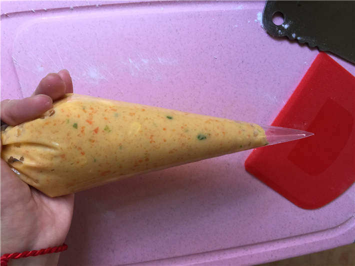 玉米鸡肉肠,将做好的鸡肉泥装入裱花袋,在裱花袋的前端剪一个小口。PS:没有裱花袋也可以用保鲜袋替代的,同样剪一个小口即可。