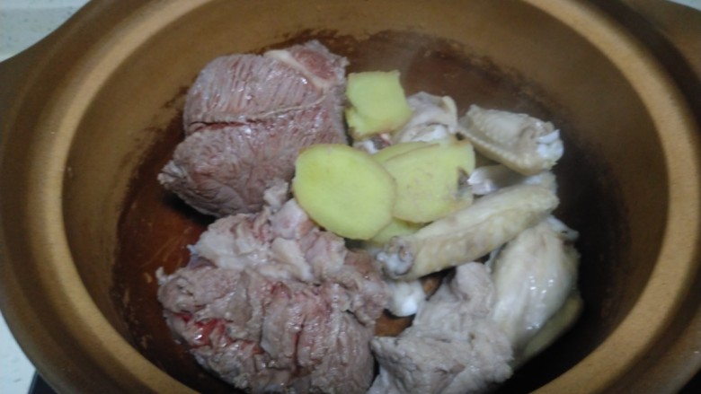 酱羊肉、牛肉、鸡翅炖土豆粉,水开后焯水,捞入砂锅中,加入姜片。