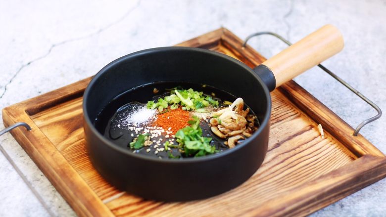 猪肉荠菜云吞,在汤碗里放入适量的小虾皮、香菜、盐、鸡精、辣椒粉,少许的香油。