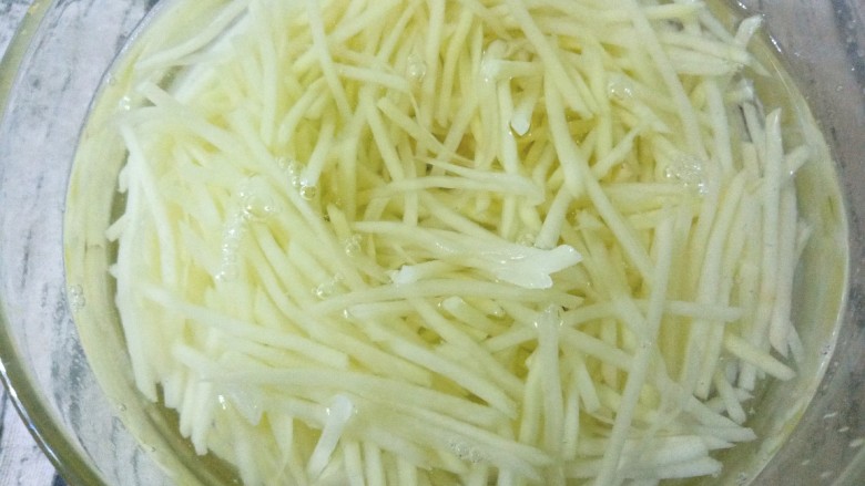 青黄椒洋葱凉拌土豆丝,冲洗后用凉水泡一下