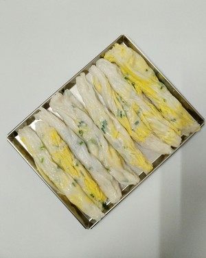 广东肠粉,用刮板从小边下板,一气呵成地刮起肠粉,装盘