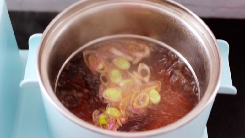 菠菜猪肝汤,汤锅中加入适量的清水,把翻炒好的葱姜汁倒入汤锅中,大火煮沸后。