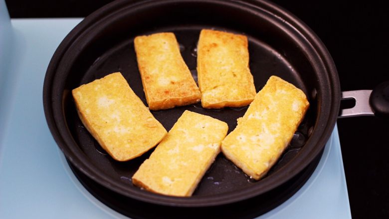 香辣煎豆腐,中小档将豆腐煎至金黄,再翻一面,两面都煎至成金黄色。