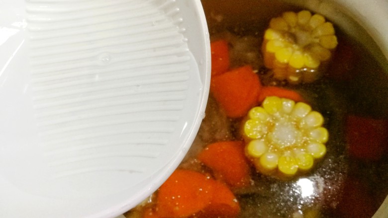 胡萝卜玉米排骨汤,加入料酒。