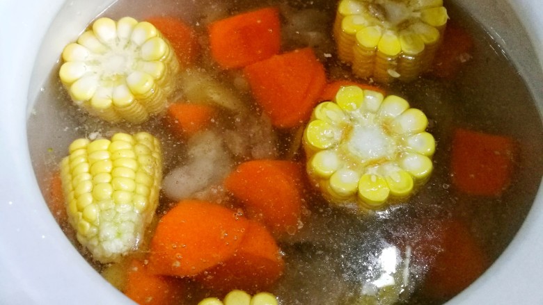 胡萝卜玉米排骨汤,加入刚刚没过食材的清水，大火煮开水后转小火煮2小时，中途多搅拌几次。