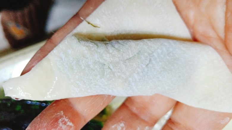 荠菜鸡蛋薄皮大混沌,在向前卷一下,再给一个角摸一点水,