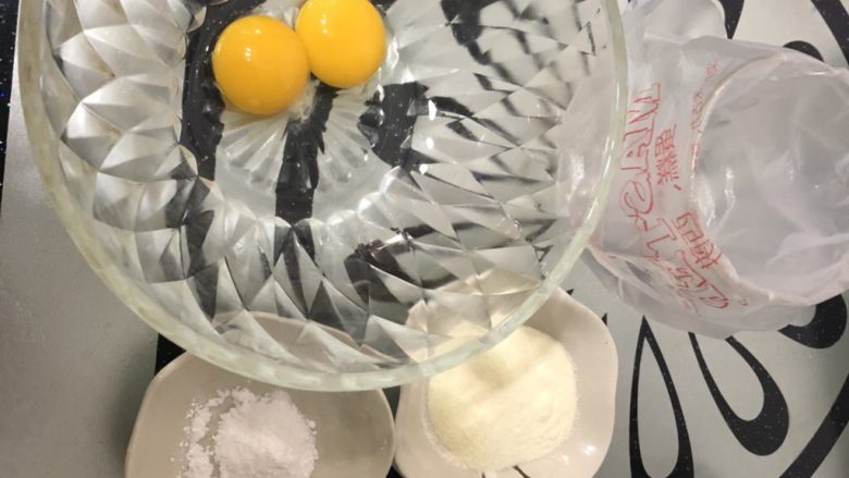 蛋黄溶豆,先把所有东西准备好,事先先用个广口杯子套上裱花袋,烤盘也事先垫上油纸或油布备用!