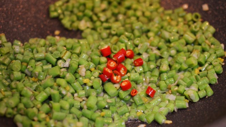 橄榄菜肉末豆角,放入豇豆和朝天椒翻炒均匀。