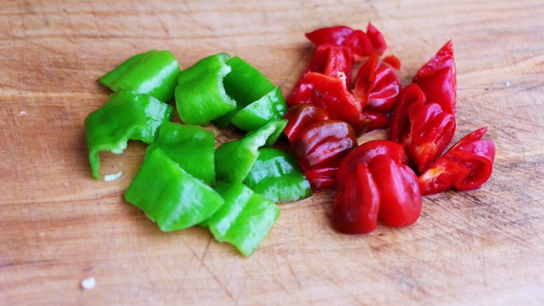 时蔬美味牛肉串,这个时候把<a style='color:red;display:inline-block;' href='/shicai/ 3445'>青尖椒</a>和红椒,用刀切成小块。