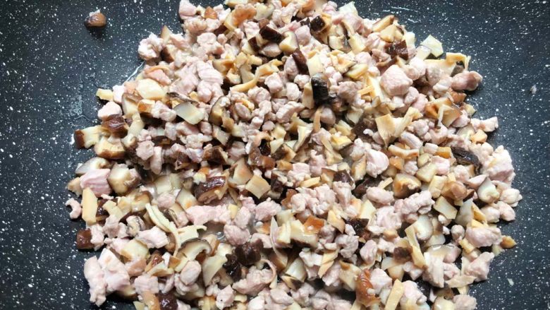 豌豆饭,锅里放入适量油,烧至8成热,把肉丁放入煸炒至变色,再放入香菇丁和鱿鱼丁一起翻炒3分钟。