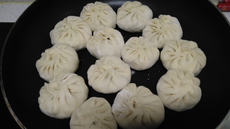 韭菜鸡蛋水煎包,不粘锅中倒入适量油,放入包子,小火煎至底部金黄。
